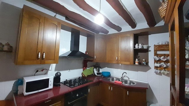 Bright kitchen with wooden cabinets and modern appliances in Bayarque village, Almeria.
