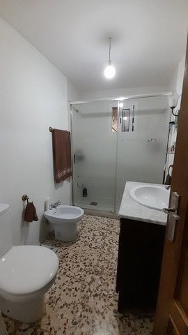 Bright bathroom with shower, toilet, and sink in a village property in Bayarque, Almeria.