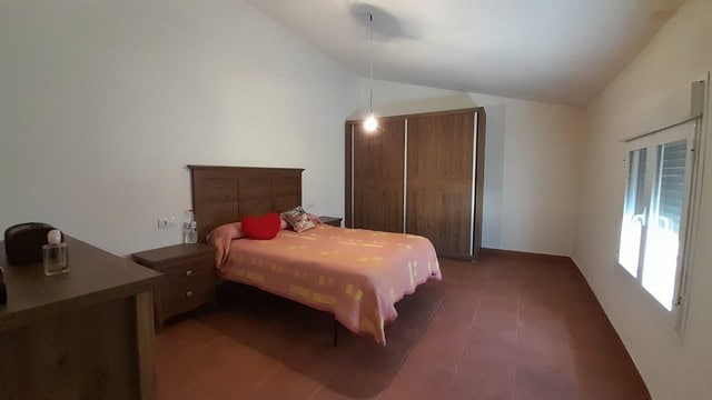 Bright bedroom with double bed and wooden furniture in Bayarque village.