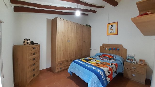 Bright bedroom with wooden furniture in a traditional village home in Bayarque, Almeria.