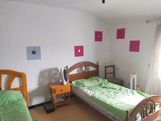 Charming bedroom in a village property in Los Olivos, Granada, featuring simple decor and colorful w.