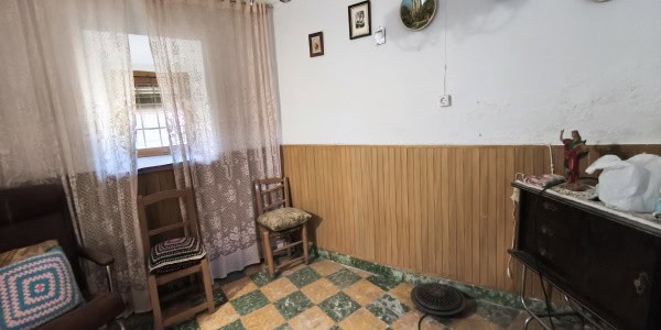 Charming village home interior in Fontanar, Jaen with wooden paneling and cozy furnishings.
