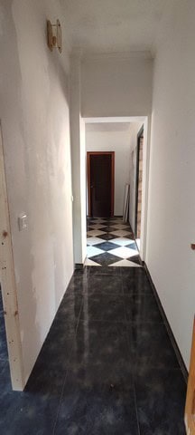Interior hallway of a rural property in Seron, Almeria, showing white walls and black tiled flooring.