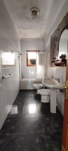 Rural property in Seron, Almeria featuring a bathroom with a bathtub, toilet, and sink in a simple,.