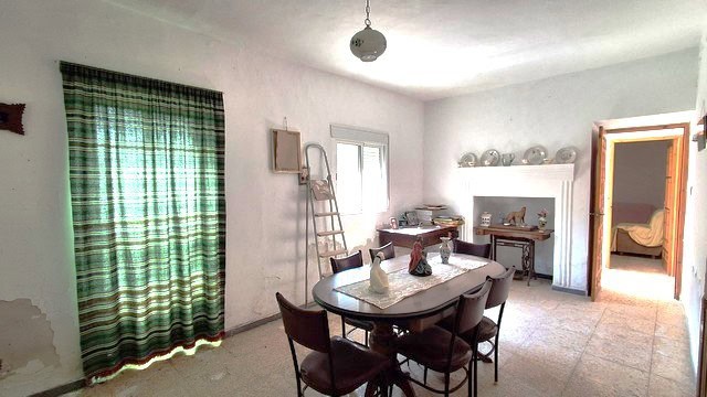 Interior view of a rustic rural property in Seron, Almeria, showcasing a cozy dining area with tradi.