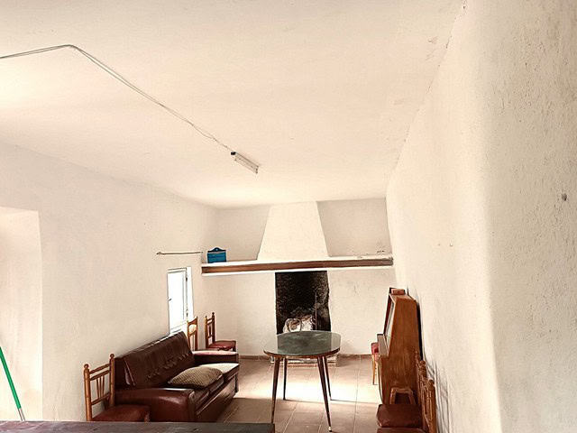 Charming rural property in Caniles, Granada, featuring a cozy living room with a fireplace and tradi.