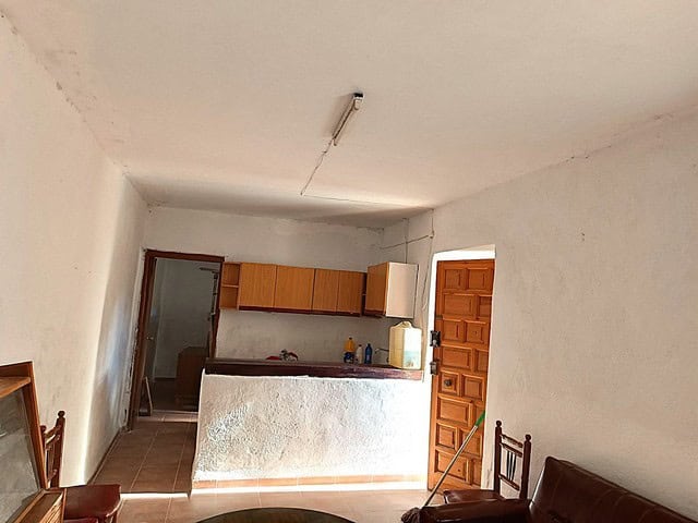 Rural property in Caniles, Granada featuring a simple interior with a kitchen and living area, ideal.