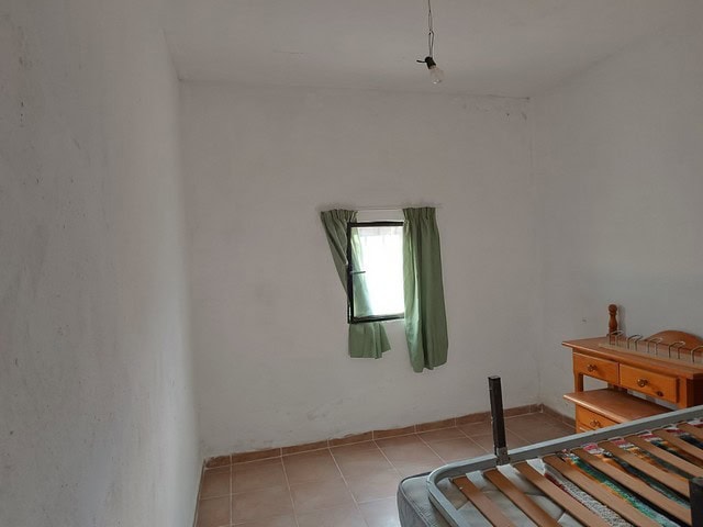 Charming interior of a rural property in Caniles, Granada, featuring a simple room with a small wind.