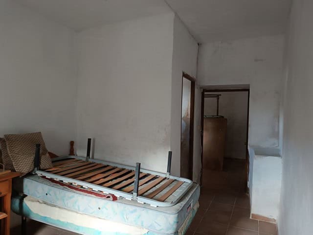 Rural property interior with unfinished bedroom and basic furnishings in Caniles, Granada.