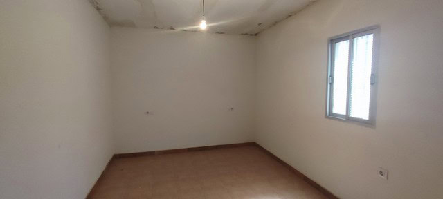 Interior of a rural property in Oria, Almeria, with plain white walls and a window.