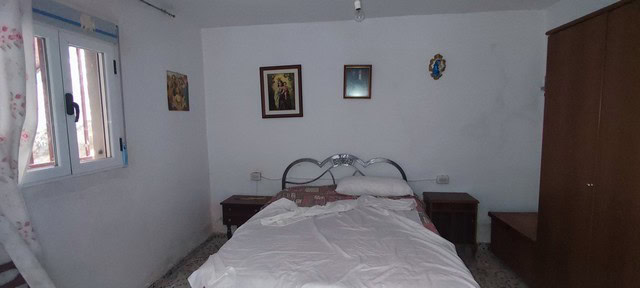 Interior of a rural house bedroom in Oria, Almeria with simple furnishings and natural light.
