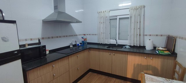 Cozy rural kitchen in Oria, Almeria with wooden cabinets and modern appliances.