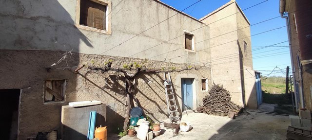 Traditional village house in Seron, Almeria with rustic exterior and outdoor storage area. Ideal for.
