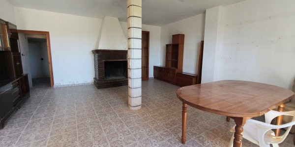 Spacious living room with fireplace and wooden furniture in a village property in Fontanar, Jaen.