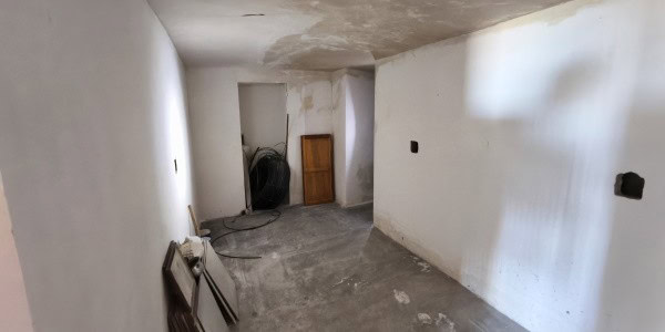 Spacious interior of a village property in Fontanar, Jaen, showing unfinished walls and flooring.