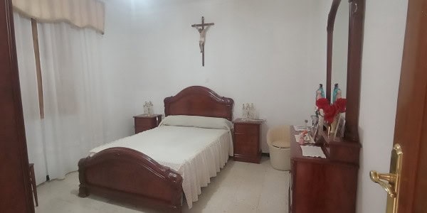 Charming bedroom in a village property in Fontanar, Jaen, featuring classic wooden furniture and sim.