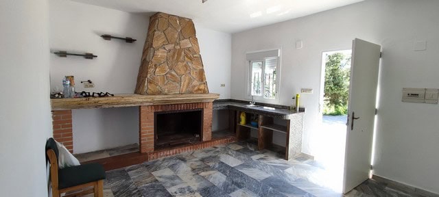 Spacious interior of a rural property in Macael, Almeria, featuring a cozy fireplace and modern kitc.