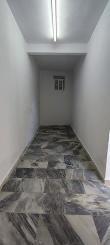Bright interior corridor of rural property in Macael, Almeria, with marble flooring and simple white.