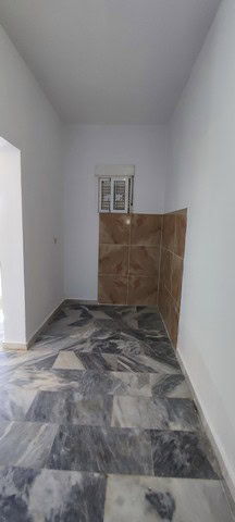 Cozy interior space of a rural property in Macael, Almeria, featuring white walls, a small window, a.