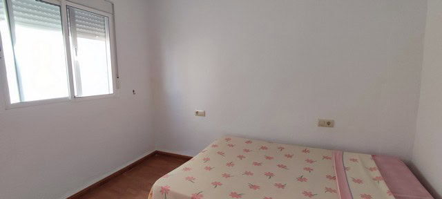Charming village property in Purchena, Almeria, with a simple bedroom and natural light from a windo.