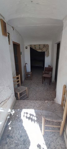 Cave house interior in La Alqueria, Granada, showcasing rustic charm and traditional architecture.
