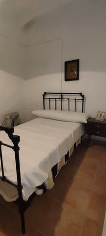 Charming bedroom in a village property in Somontin, Almeria, featuring a vintage iron bed and cozy d.