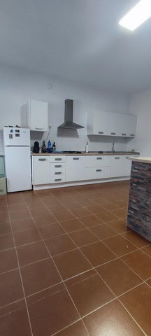 Modern kitchen with white cabinets and stainless steel appliances in Villanueva de las To, Granada.