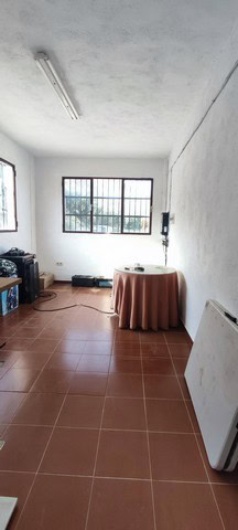 Rural property interior with large windows and simple furnishings in Villanueva de las To, Granada.