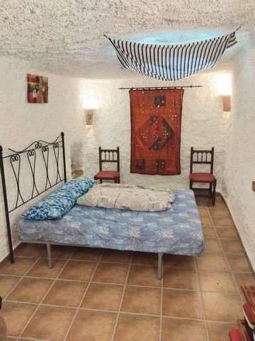 Unique cave house interior in Cantarranas, Granada with rustic decor and cozy atmosphere.