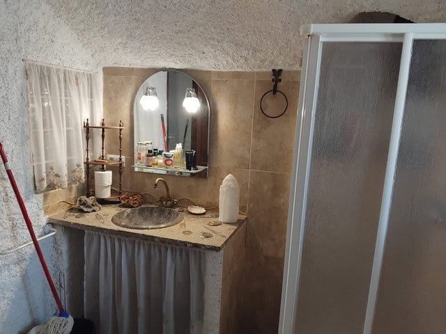 Traditional cave house bathroom in Cantarranas, Granada with rustic decor and natural stone features.
