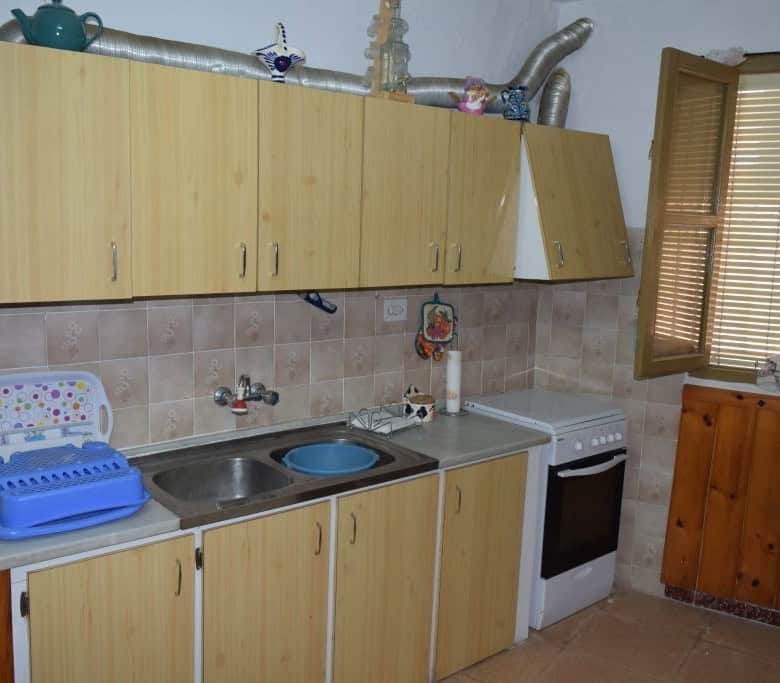 Charming cave house kitchen with basic appliances in Caniles, Granada, offering rustic living in a u.