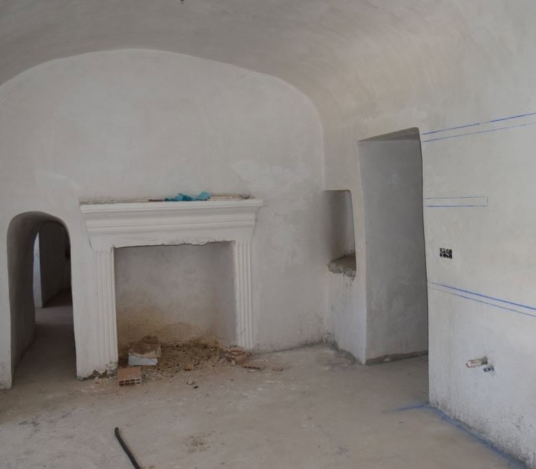 Cave house interior in Caniles, Granada, under renovation with white walls and arched ceilings.