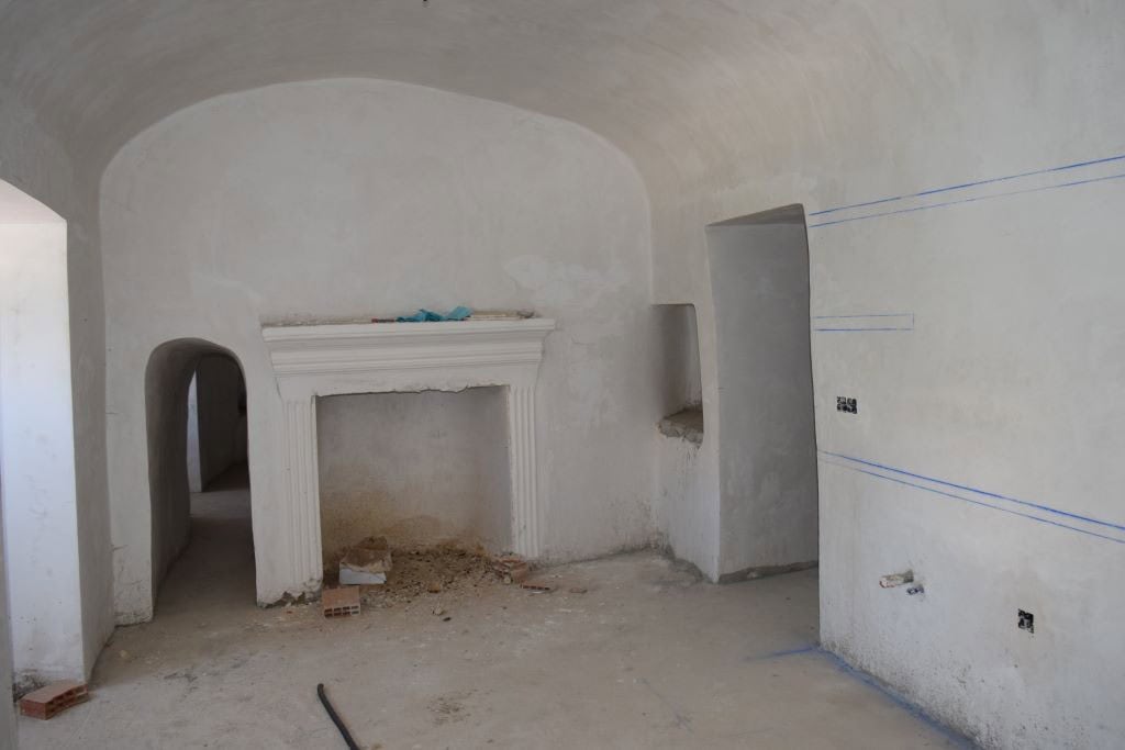 Cave house interior in Caniles, Granada, under renovation with white walls and arched ceilings.