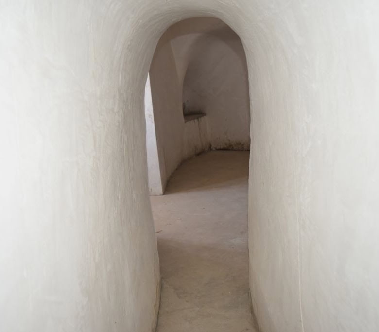Unique cave house interior in Caniles, Granada, showcasing smooth white walls and arched passageways.