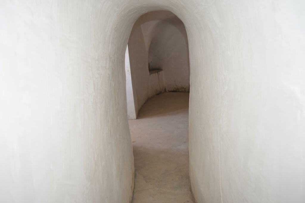 Unique cave house interior in Caniles, Granada, showcasing smooth white walls and arched passageways.