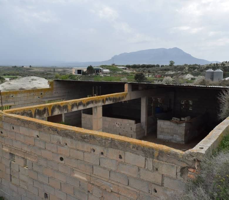 Cave house under construction in Benamaurel, Granada, with scenic mountain views in the background.