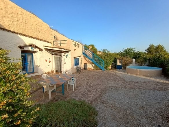 Cave house in Cortes de Baza, Granada with outdoor seating and scenic surroundings.