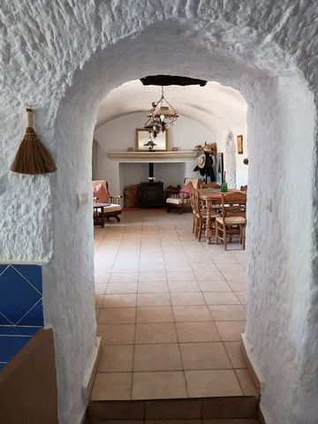 Interior view of a traditional cave house in Cortes de Baza, Granada, showcasing rustic decor and co.