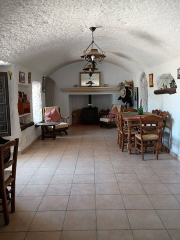 Charming cave house interior with rustic furniture and cozy ambiance in Cortes de Baza, Granada.