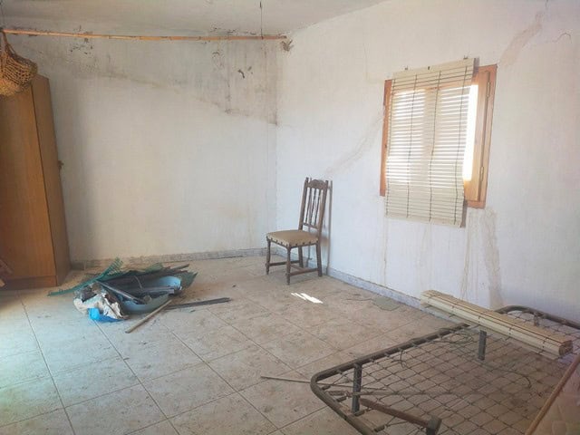 Spacious interior of a village property in Somontin, Almeria, with unfinished walls and basic furnis.