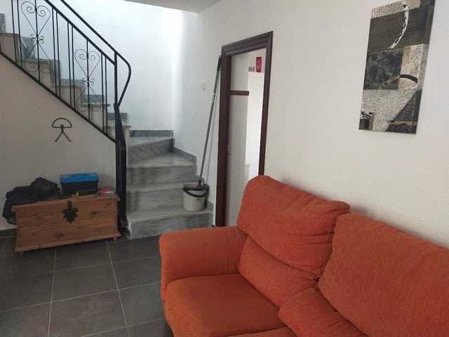 Cozy interior of a village property in Urracal, Almeria, featuring a comfortable orange sofa and sta.