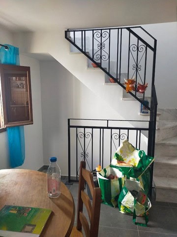 Interior staircase with decorative black iron railing in Urracal property.