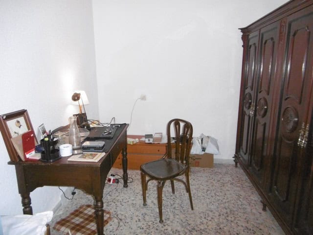 Charming village home interior in Urracal, Almeria, featuring a wooden desk, chair, and wardrobe.
