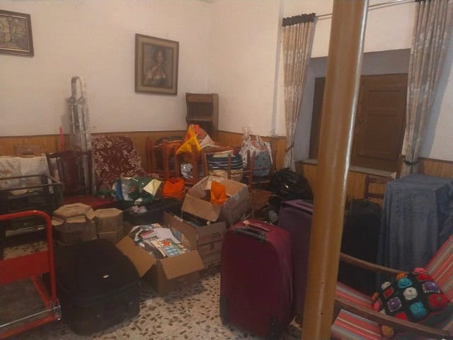 Charming town house interior with luggage, boxes, and furniture in Velez Blanco, Almeria.