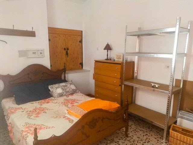 Charming bedroom in a town house located in Velez Blanco, Almeria, featuring wooden furniture and si.