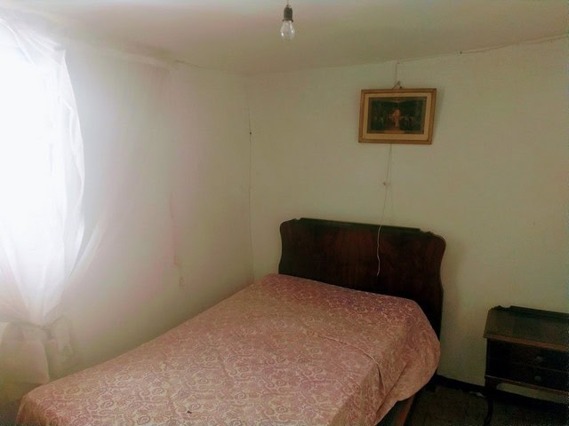 Interior view of a town house in Velez Blanco, Almeria, showcasing a simple bedroom with a bed, wind.