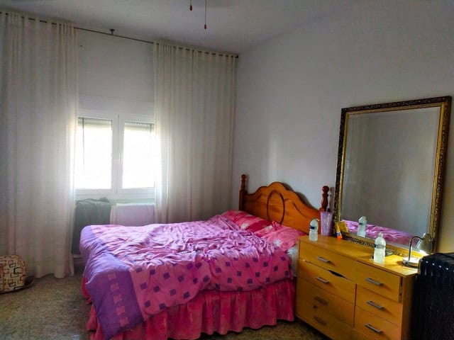 Charming villa in Hijate, Almeria, featuring a cozy bedroom with pink bedding and natural light.