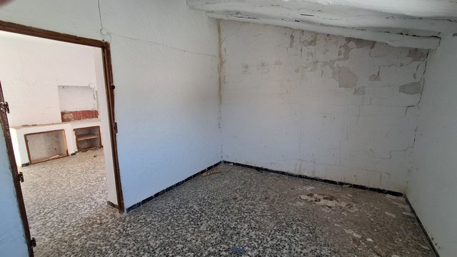 Interior view of a rustic town house in Tijola, Almeria, showing unfinished walls and flooring.