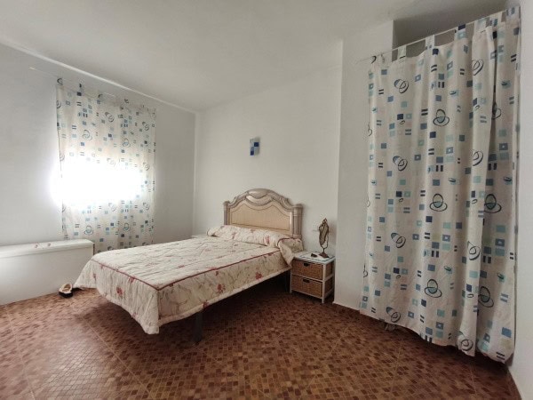 Charming cave house interior in Huesa, Jaen, featuring a cozy bedroom with vintage furniture and nat.