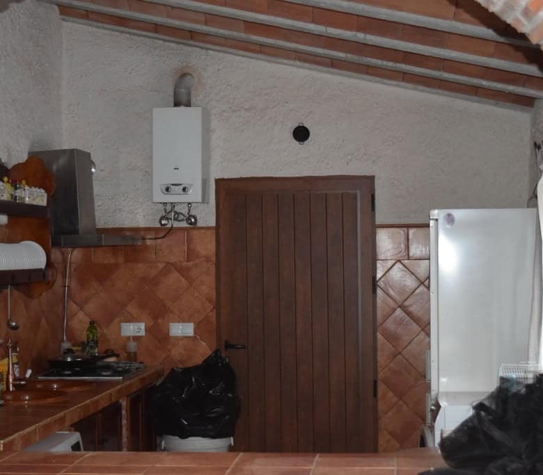 Cave house kitchen with rustic decor, white walls, and wooden accents in Cuevas del Campo, Granada.